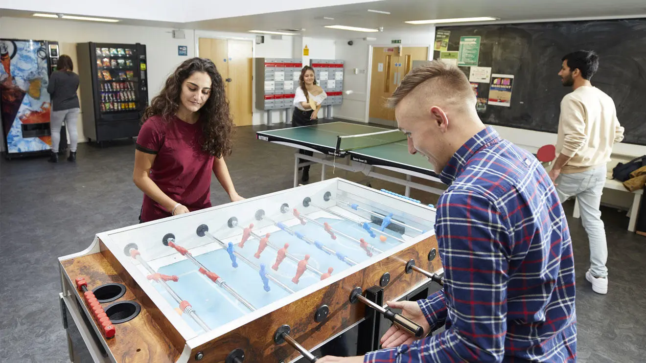 Students playing table football and table tennis in the Chantry common room