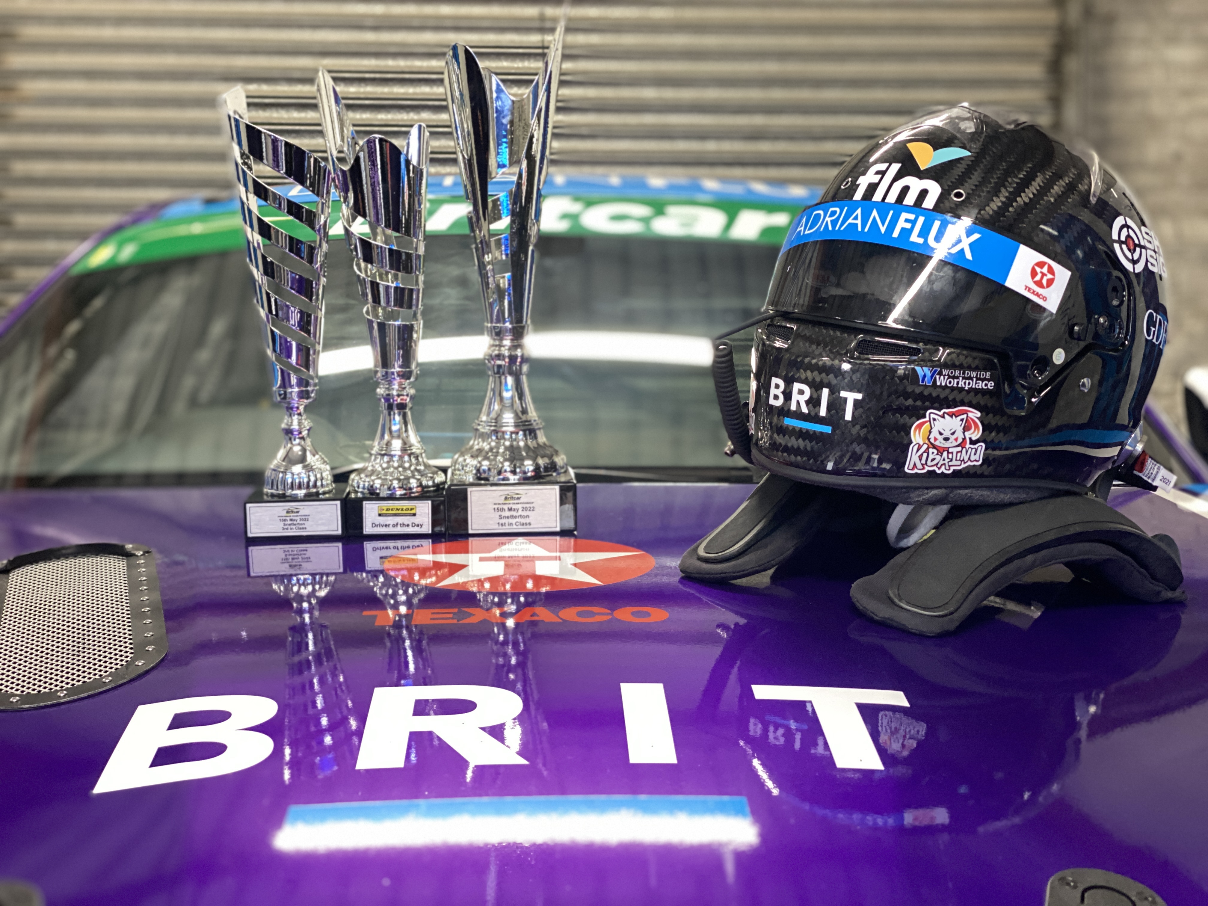 Image shows three Team BRIT trophies and racing helmet