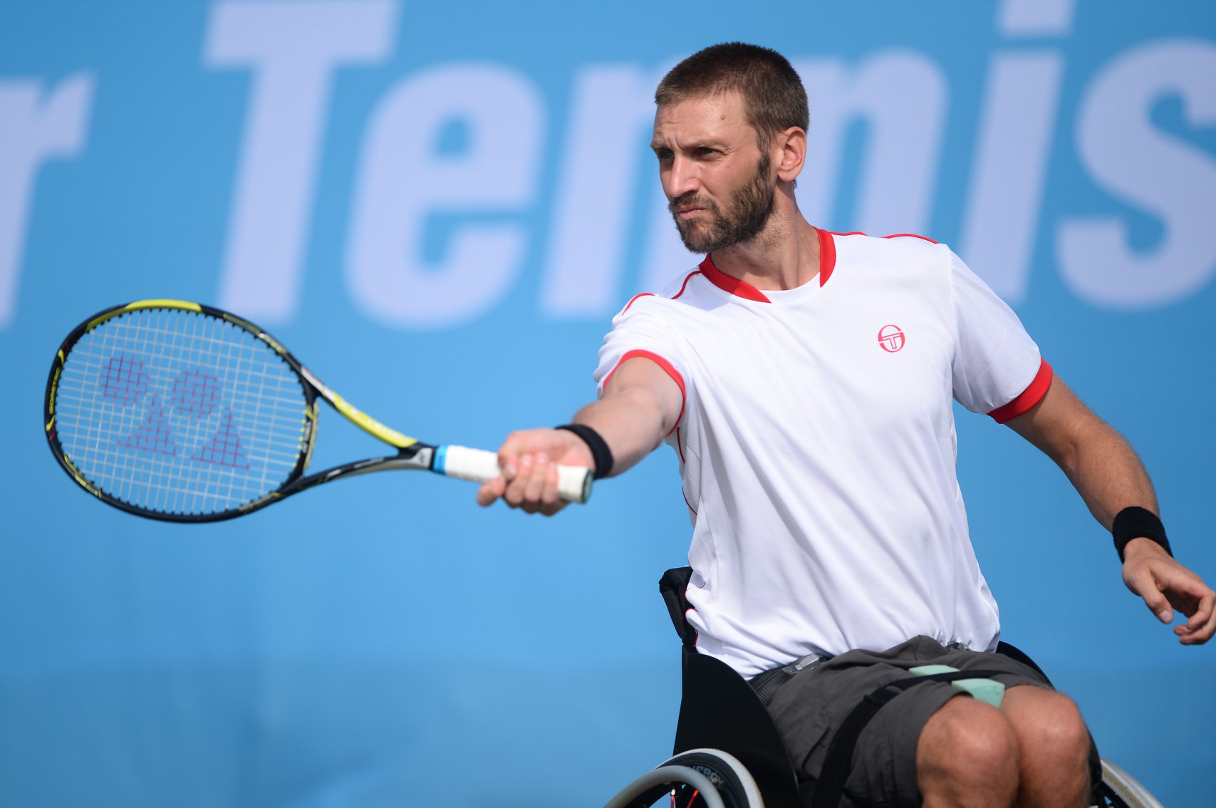 Picture shows Chris playing wheelchair tennis
