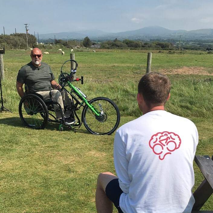 Picture of Harrison interviewing a man on a handbike for his documentary