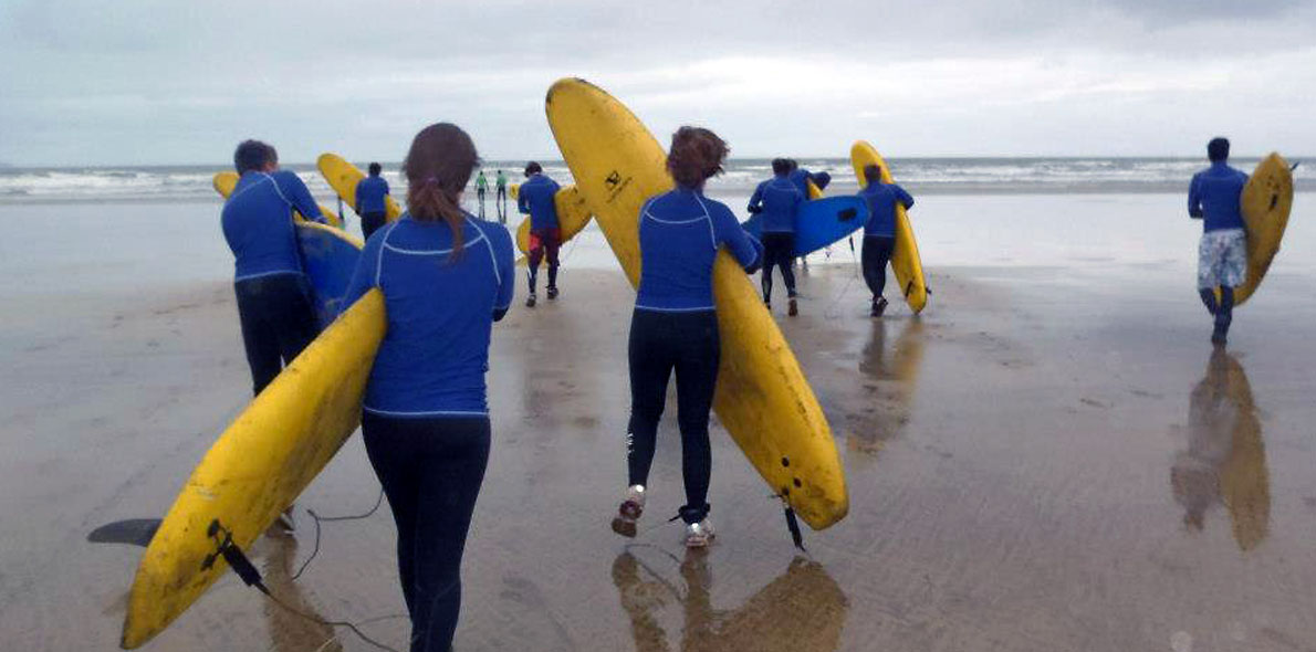 People carrying surfboards on a beach