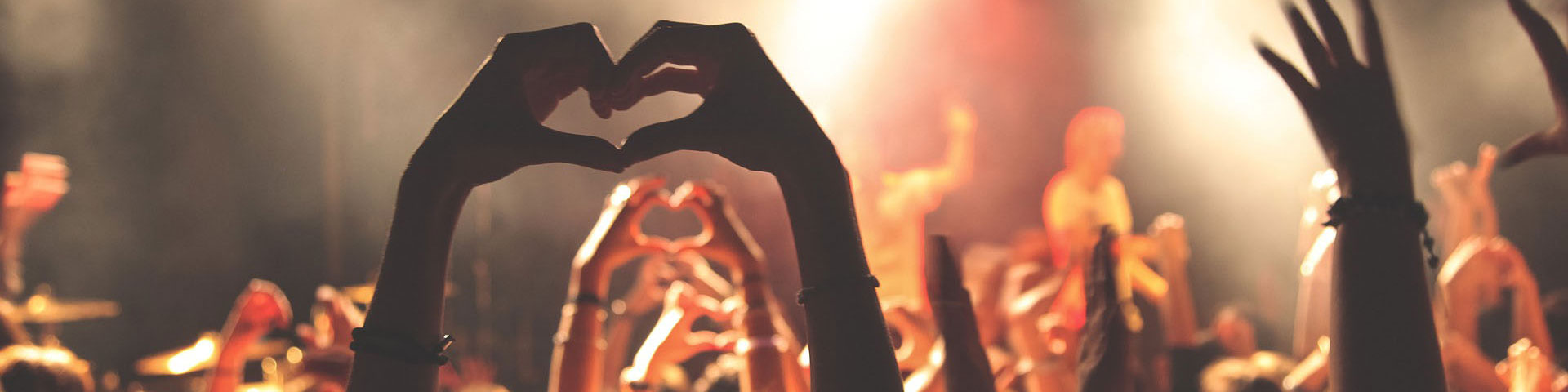 Crowd creating heart shapes with their hands