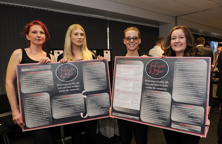 Members of the Ladies Only Coaching Innovation Project with their poster display