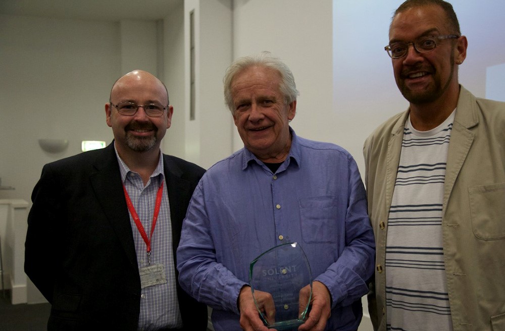 Picture of George Carey receiving his professorship at Solent - with lecturer Stephen Desmond, and Dean of School Paul Marchbank