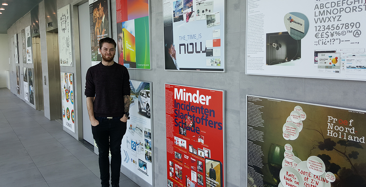 Adam Lane standing in front of a wall of posters