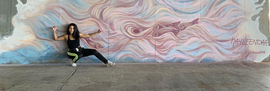 Picture of Kayleen in front of a mural she created