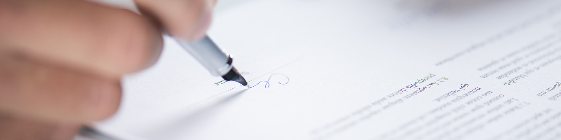 a hand writing with a pen on a legal document