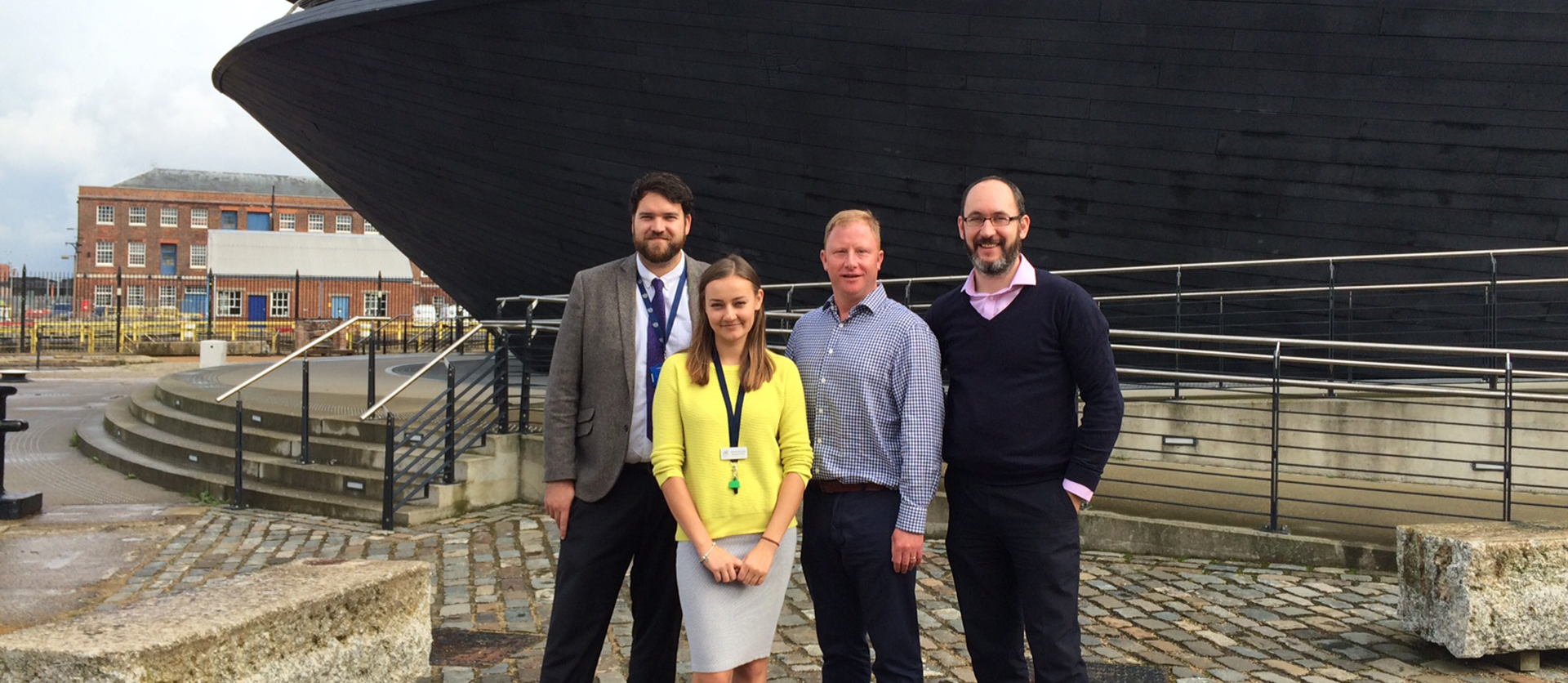 Karina Smulska standing outside the Mary Rose Museum with Paul Griffiths, Head of Operations, James Rodliff, Visitor Operations Manager, and Solent University employability adviser, Matt Williams
