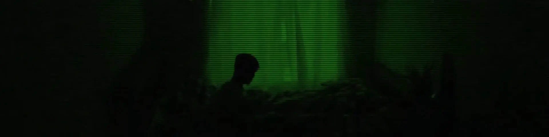 A shot from Nathan's film: a boy sitting up in the dark, shown in 'night vision' green