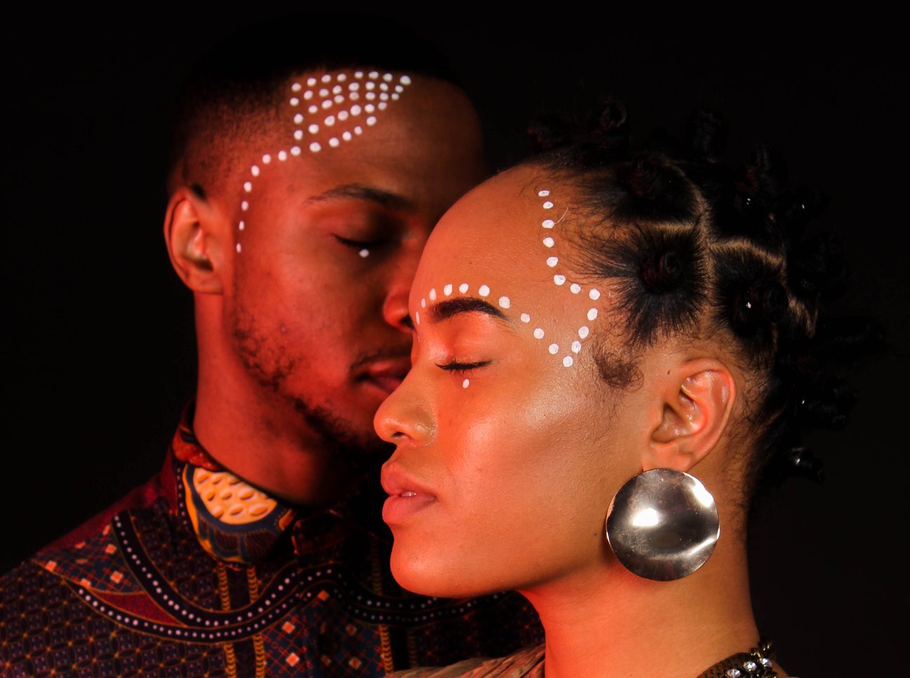 Picture of Nishan Greyson's undergraduate work, shows two black models with dots on their face - eyes are closed. 