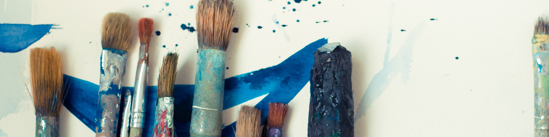 Image shows paintbrushes on a blue and white background