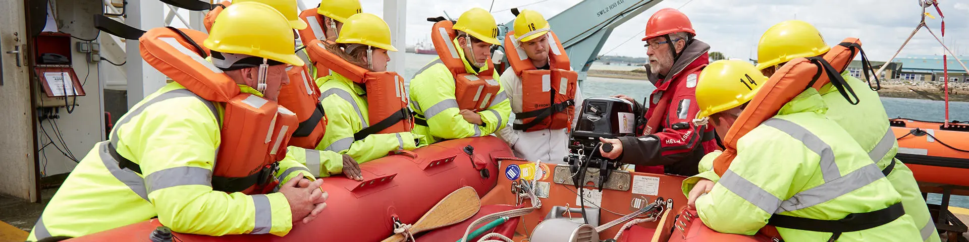 Seafarers training on a survival craft at Warsash wearing PPE equipment