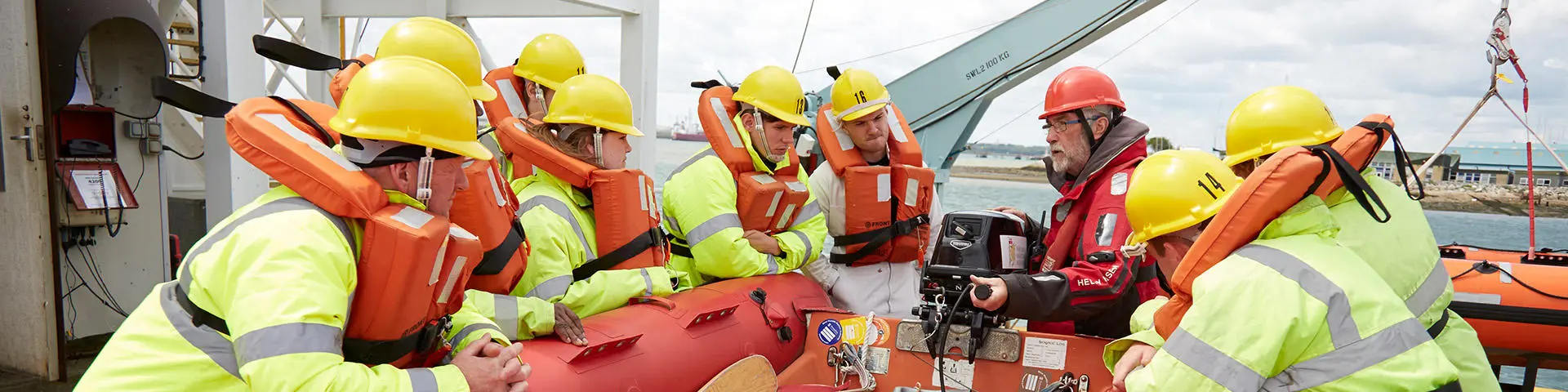 Seafarers training on a survival craft at Warsash wearing PPE equipment