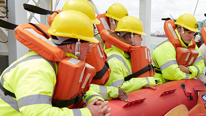 Seafarers training on a survival craft at Warsash wearing PPE equipment
