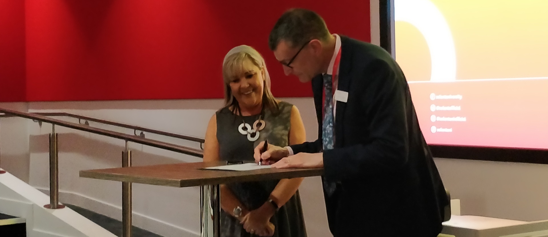 Diane Celella and Professor Graham Baldwin signing to show the launch of the SBID Centre of Excellence