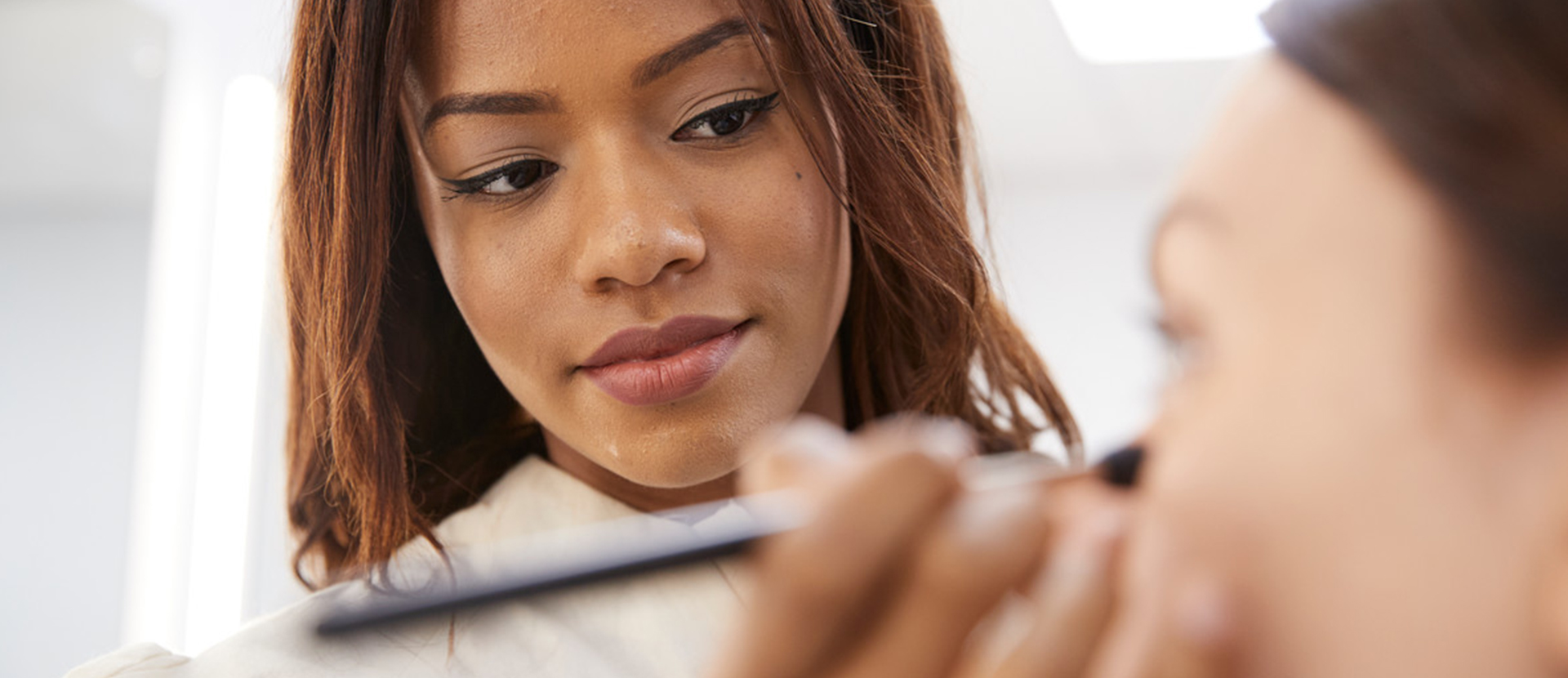 BA (Hons) Hair and Make-up student applying make-up to a model