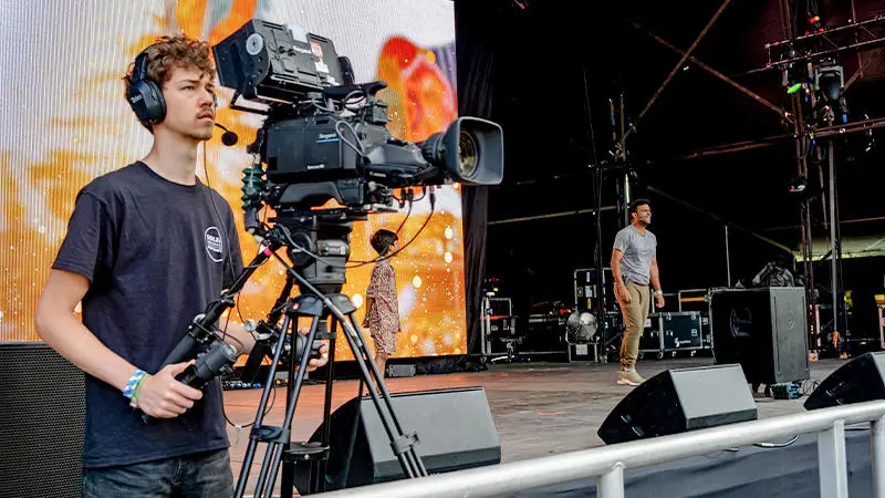 Student working behind the camera on the main stage at Camp Bestival