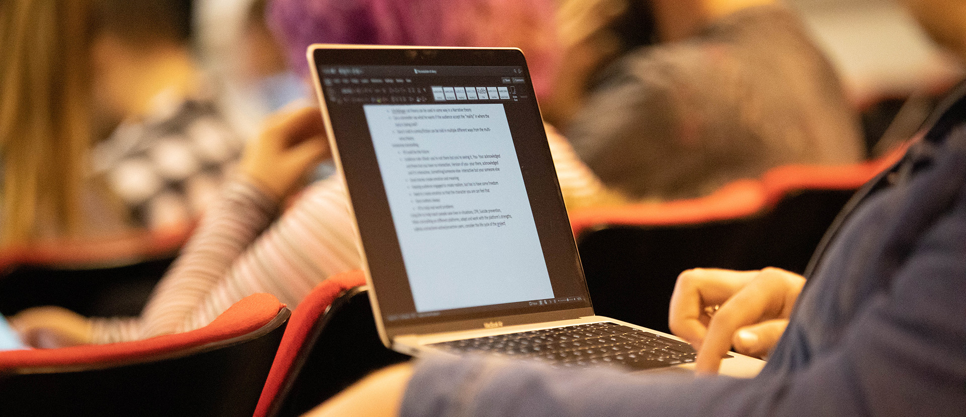Picture of person typing on laptop at Evolution of Story symposium