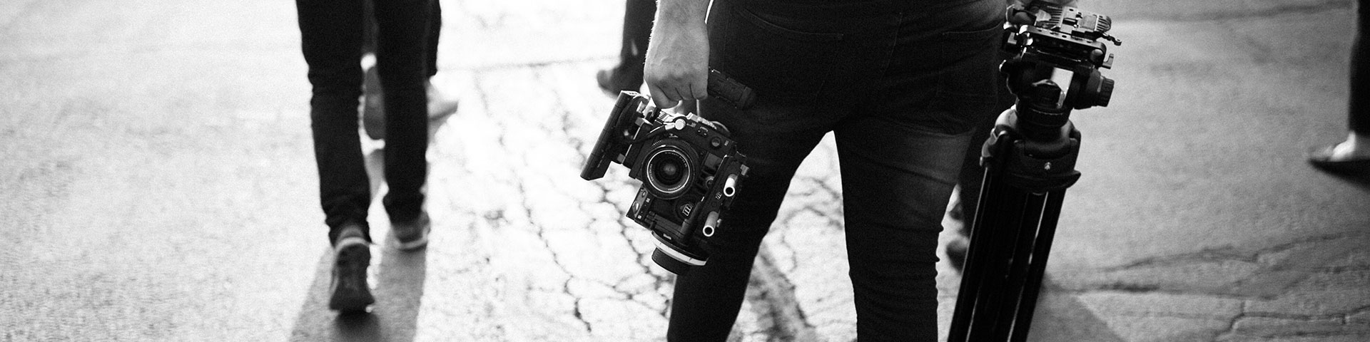 Image shows students walking with cameras and tripods