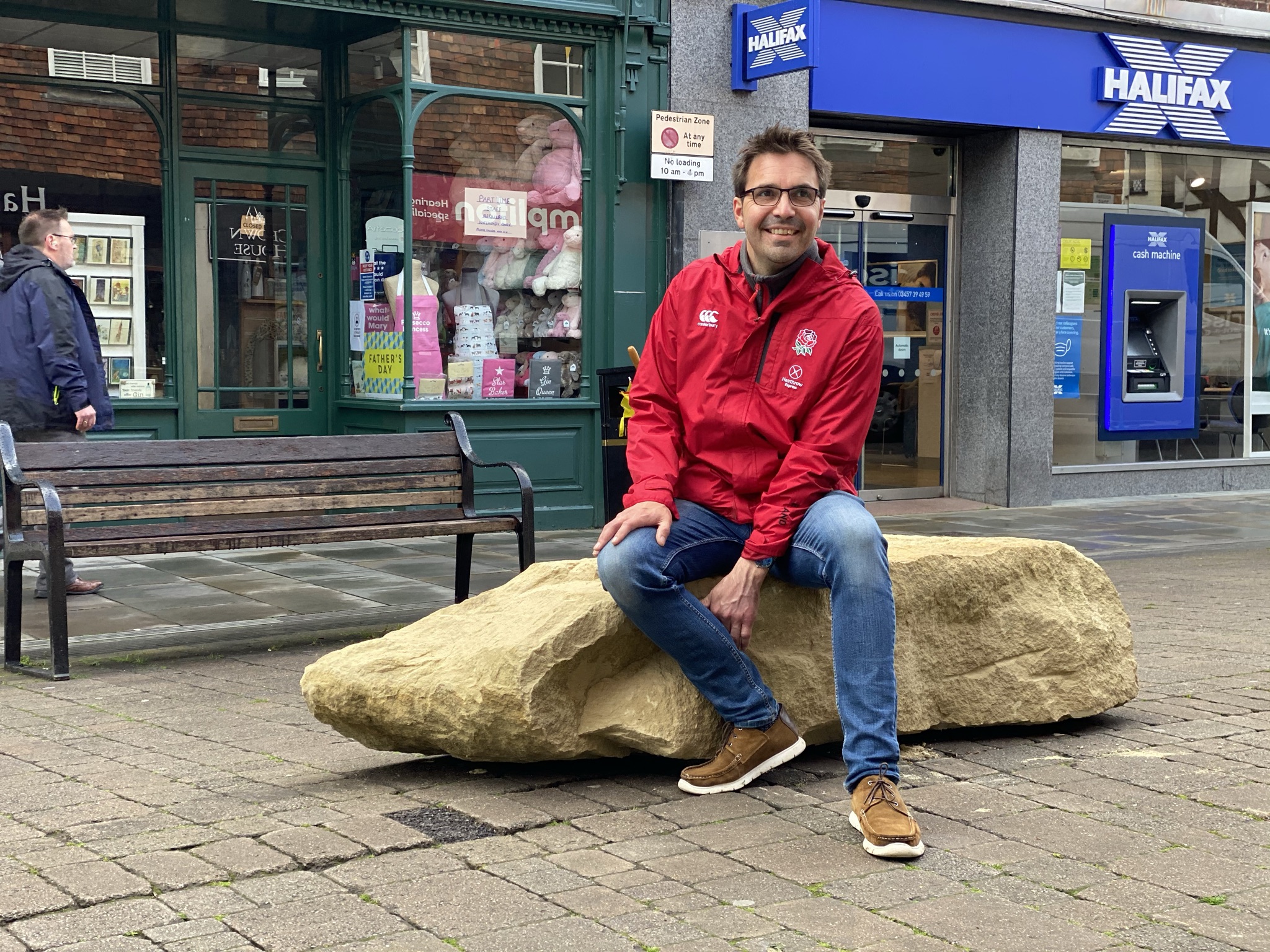 Picture shows artist Tim, sat on an element of the sculpture in Salisbury.