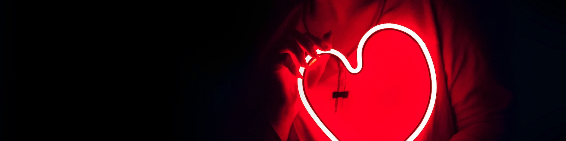 Person holding a neon red heart