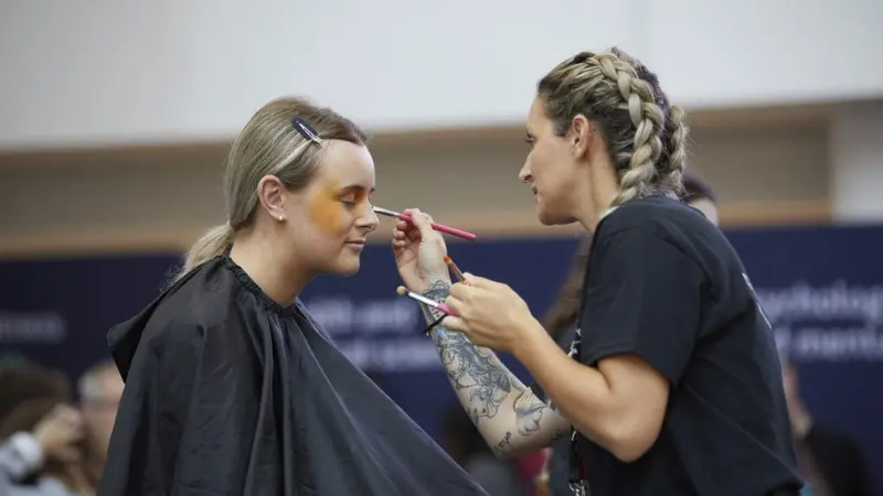 A make up artists doing make up on a model