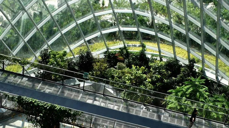 A building with big glass windows and walkways overlooking a green landscape