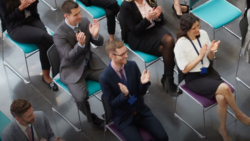 Overhead shot of a conference audience applauding