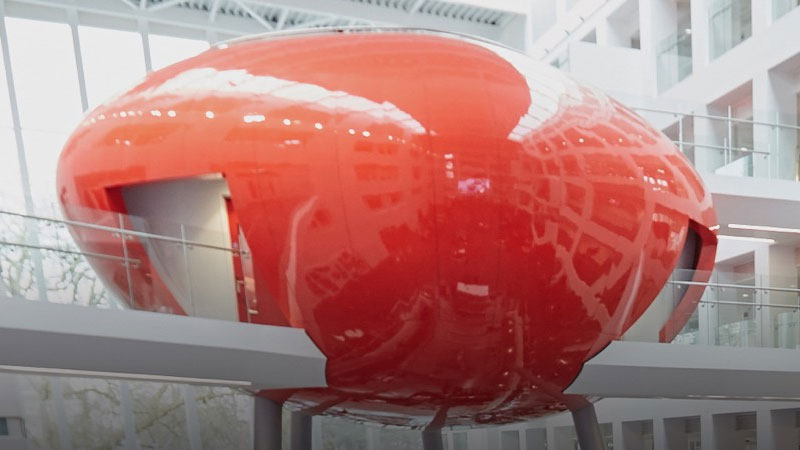 A red lecture theatre on stilts in a white building at Solent University, Southampton