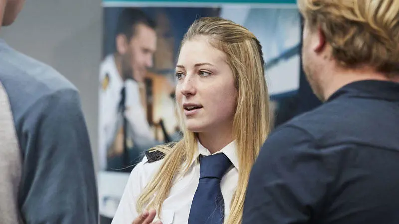 A female officer cadet talking to prospective students