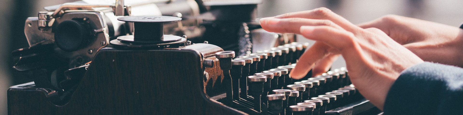 A person typing on an old-fashioned typewriter