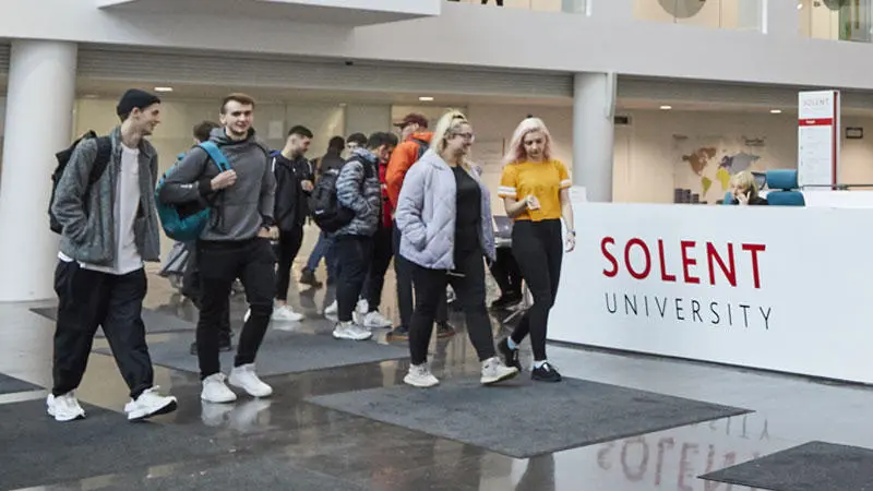 group of male and female students in the Spark Atrium building