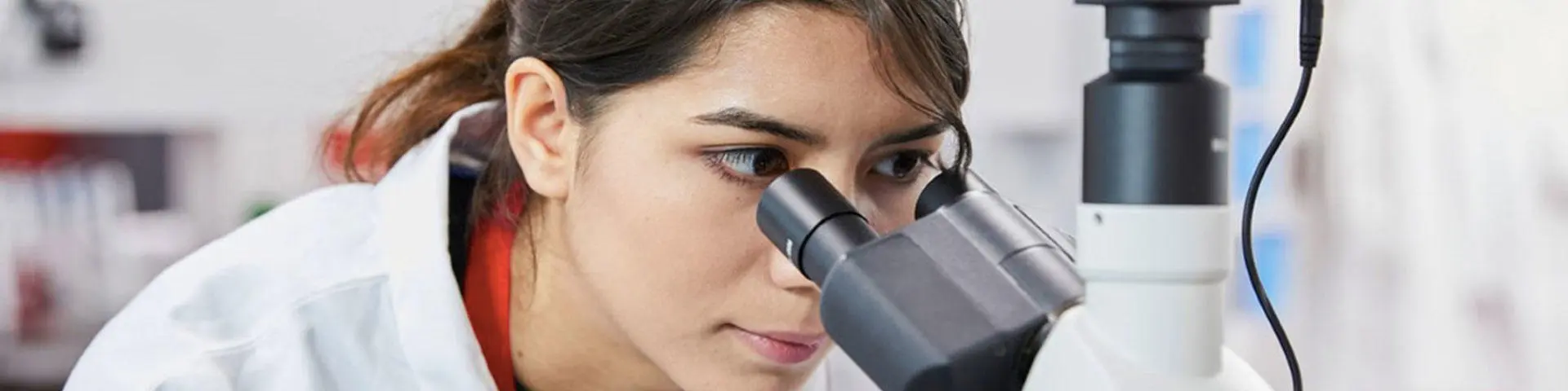Elena looking into a microscope