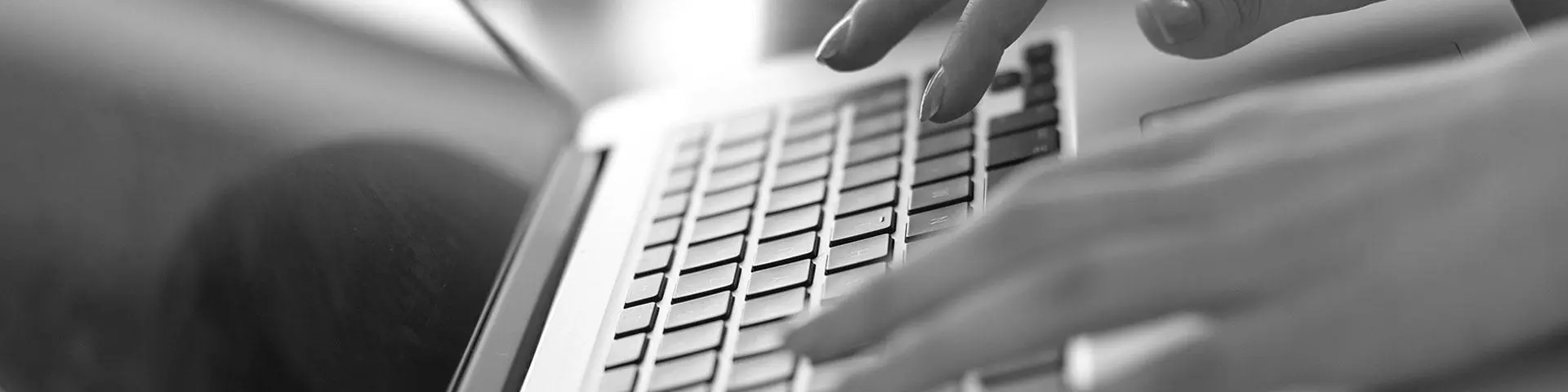A person typing on a laptop keyboard