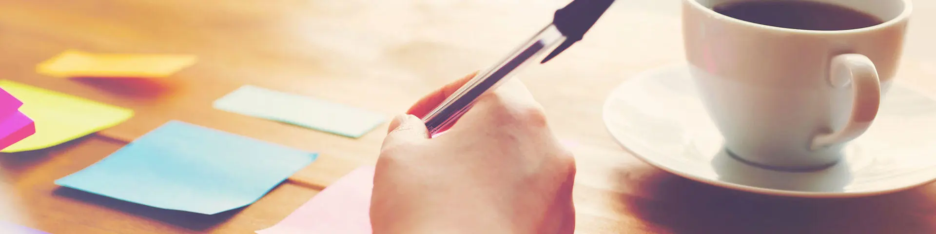 A person writing on post-it notes with a biro.