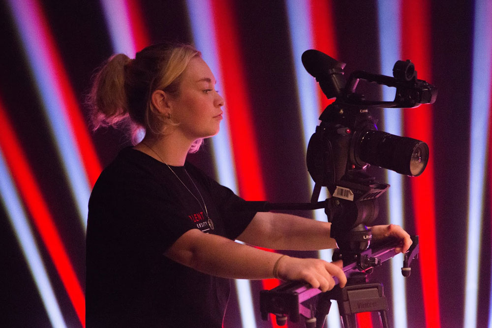 A female Solent Media operating a TV camera