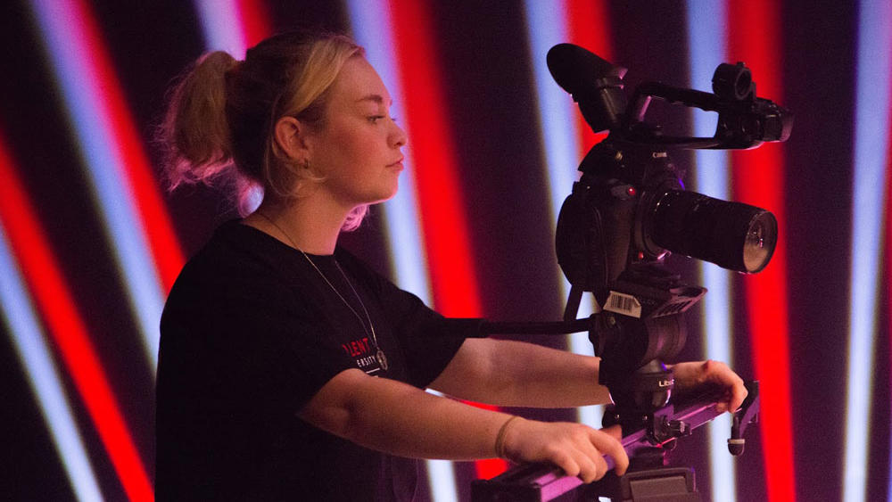 A female Solent Media operating a TV camera