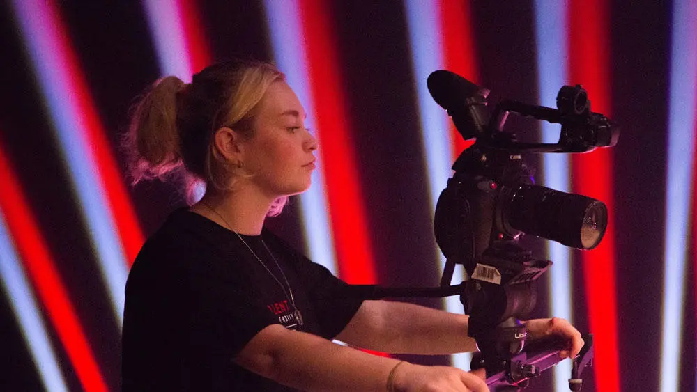 A female Solent Media operating a TV camera