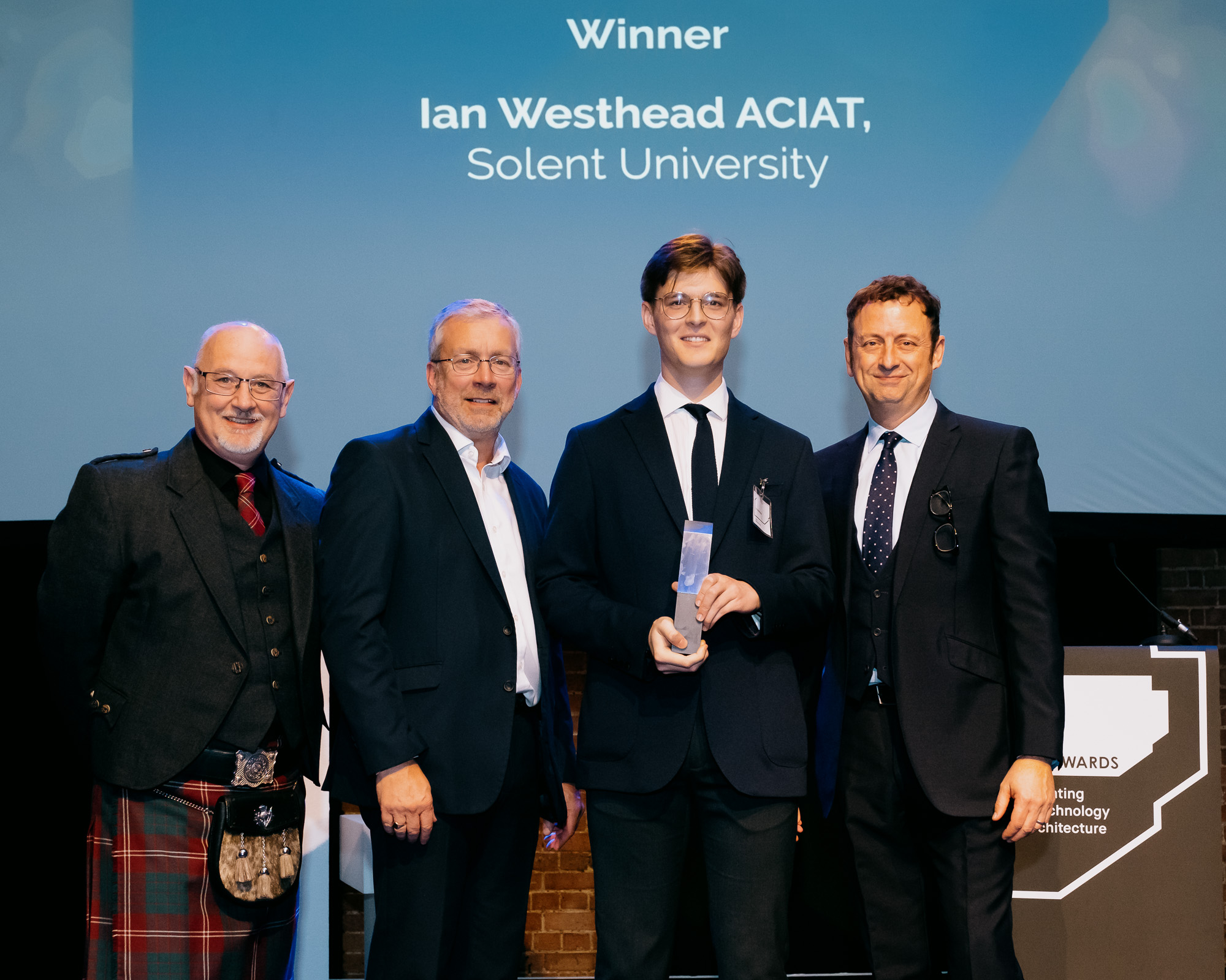 Ian Westhead pictures with his award along with CIAT President, Kevin Crawford, and host Matt Allwright
