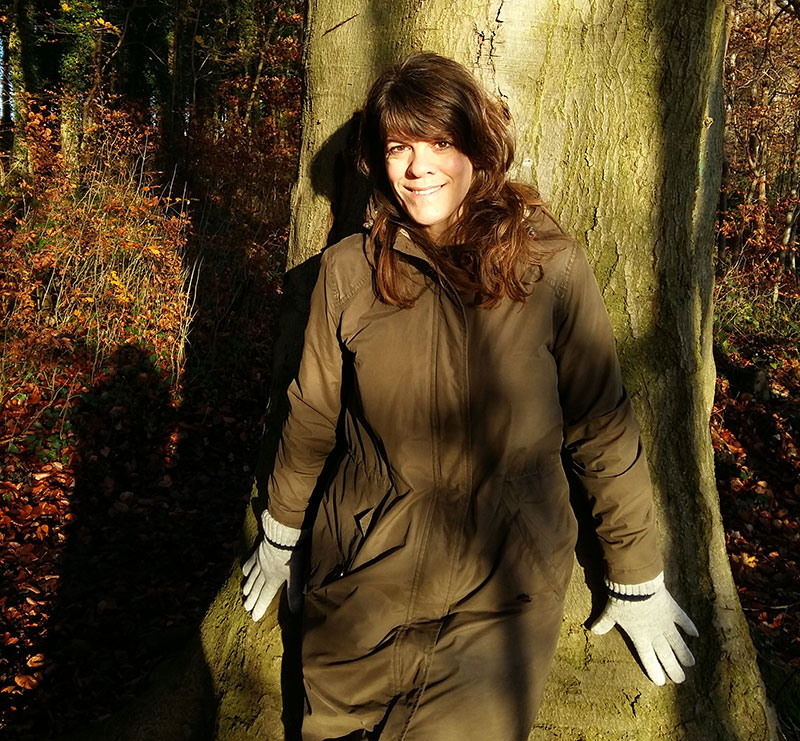 Alison Howell standing against a tree