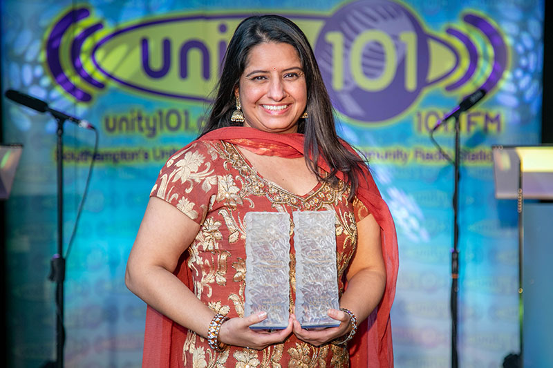 Geeta Uppal at the Unity 101 Awards with the Widening Participation Team's trophies