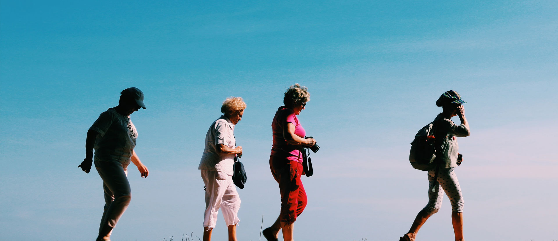 Four older women going for a walk in the sun