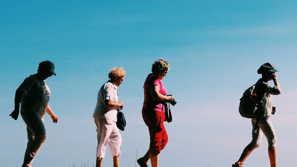 Four older women going for a walk in the sun