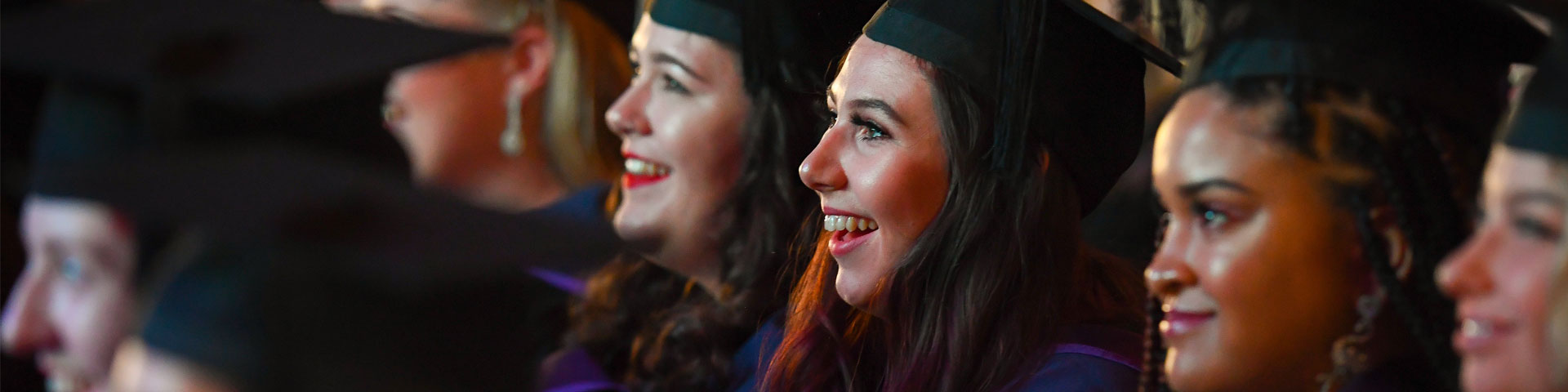 Graduating students smiling in the ceremony