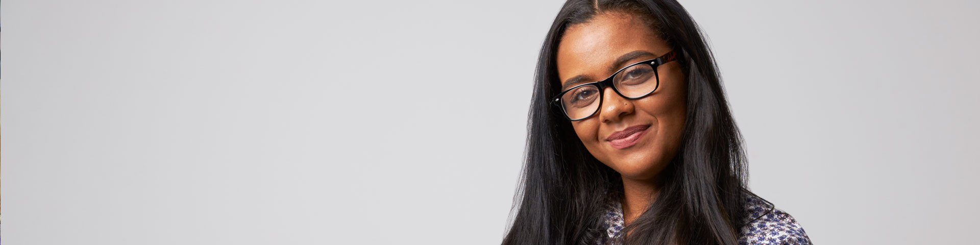 Woman wearing glasses and smiling at the camera
