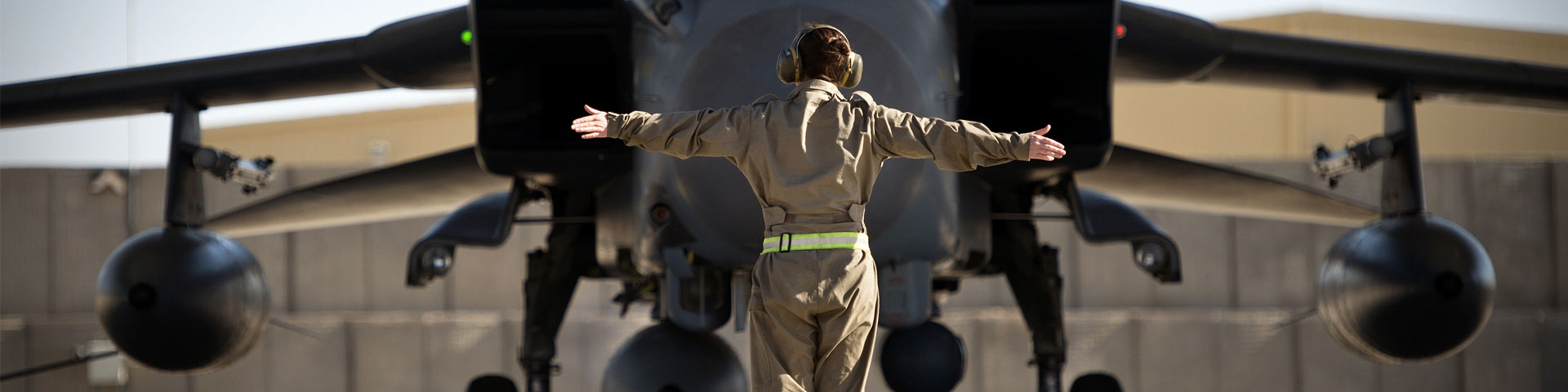 An aircraft engineer guiding an RAF jet