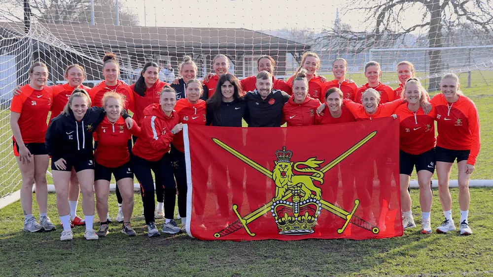 A group photo of the British Army Women's Football Team in front of a goal post.