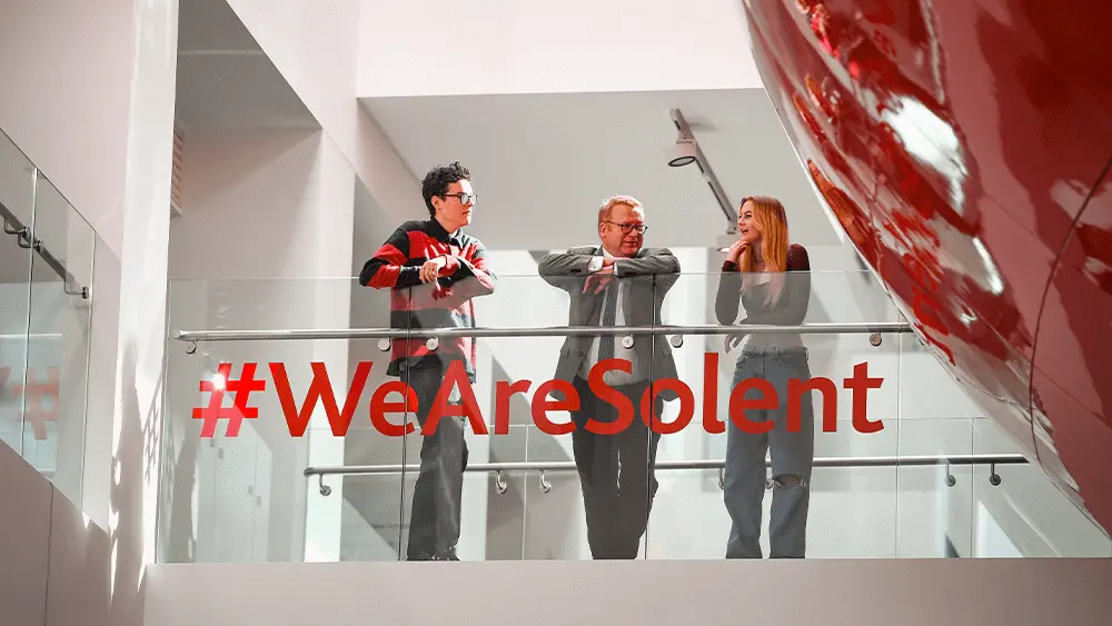 Vice-Chancellor Professor James Knowles on the balcony in The Spark with two students.