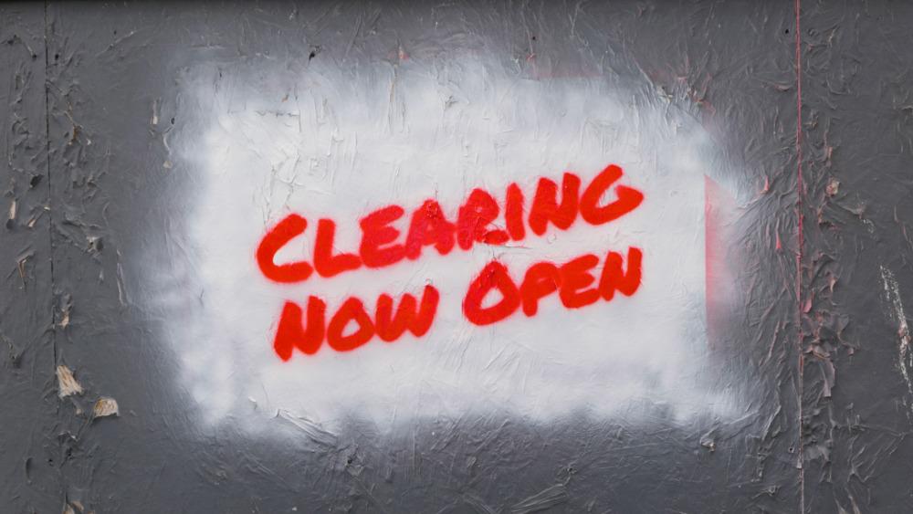 Spray paint sign in writing 'Clearing Now Open'