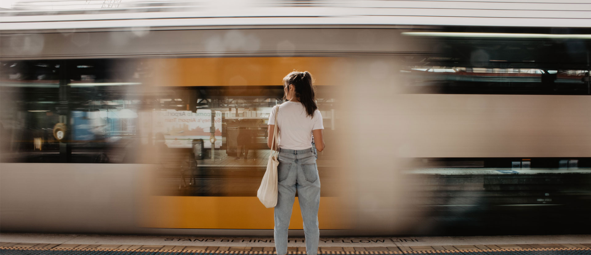 Woman standing on a train platform as a train goes by